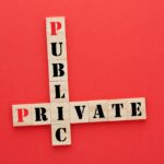 The Priest & the Prof Scrabble tiles that spell the words "Public" and "Private" are placed on a red background with the "I" overlapping.