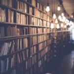 A photograph of bookshelves lit by bare bulbs hanging from the ceiling.